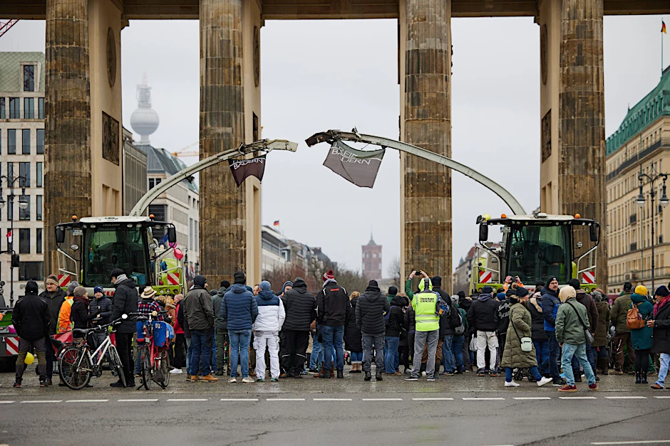 Landwirte stehen mit ihren Erntemaschinen und Traktoren vor dem Brandenburger Tor.  
