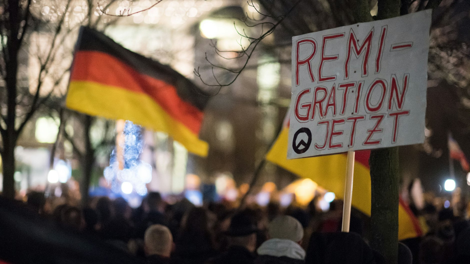 Eine Mahnwache rechter Gruppen steht mit einem Schild ("Remigration Jetzt") vor dem Bundeskanzleramt in Berlin.