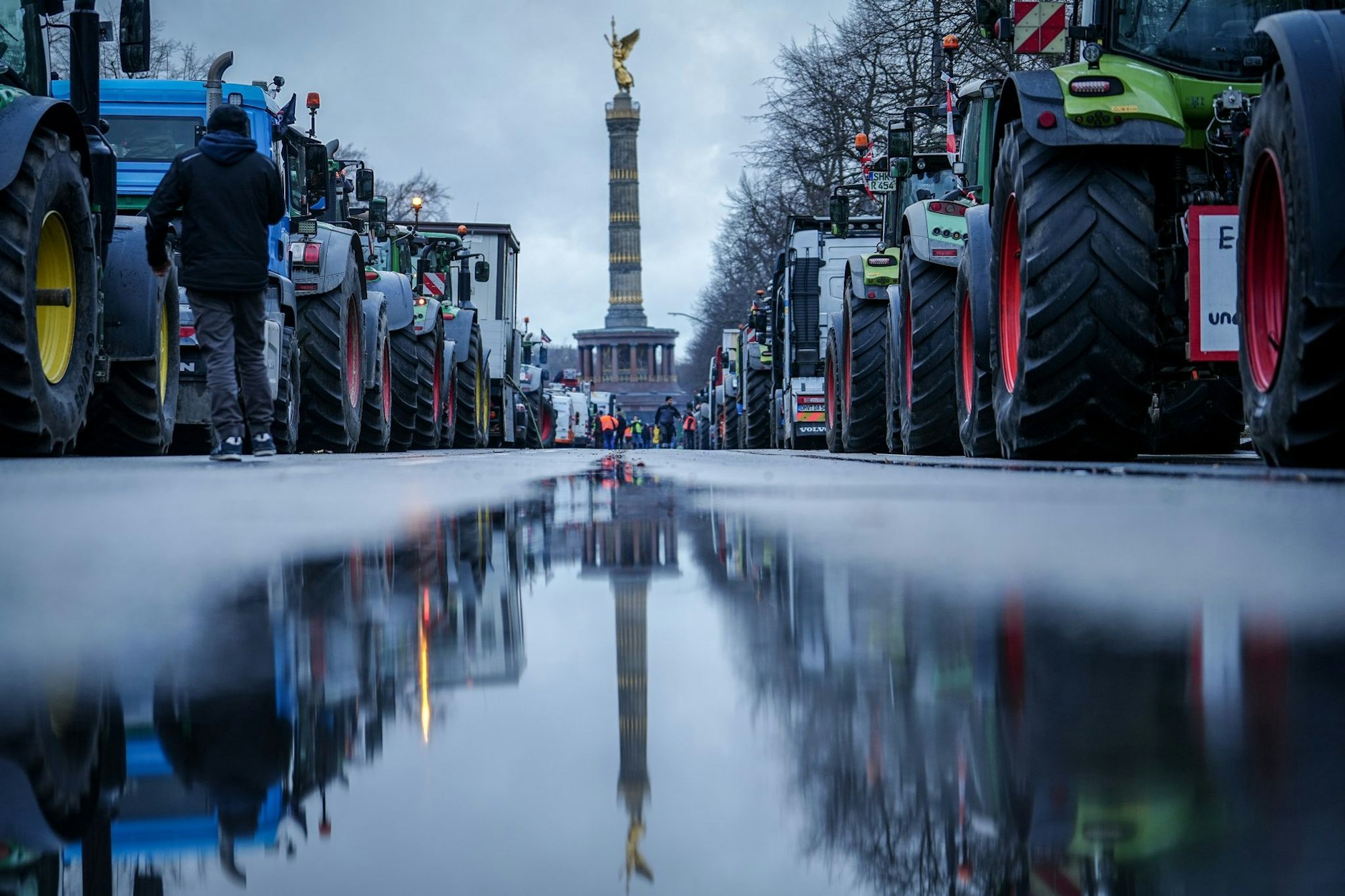 Die Siegessäule und Traktoren spiegeln sich in einer großen Pfütze. Etwa 3000 Traktoren haben sich zum Abschluss der Aktionswoche der Landwirte auf den Weg nach Berlin gemacht.