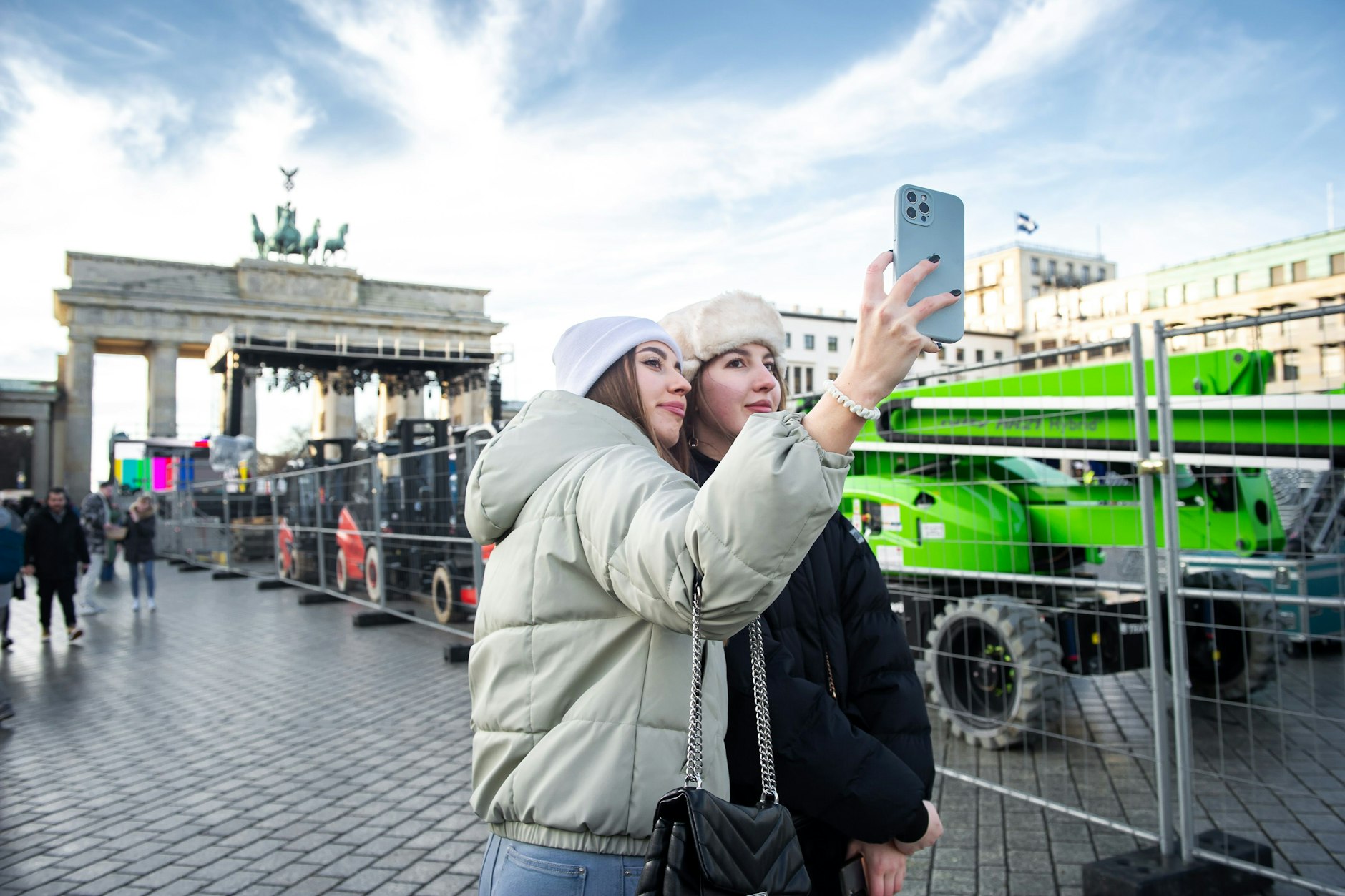 Touristen posieren vor Treckern am Brandenburger Tor in Berlin.