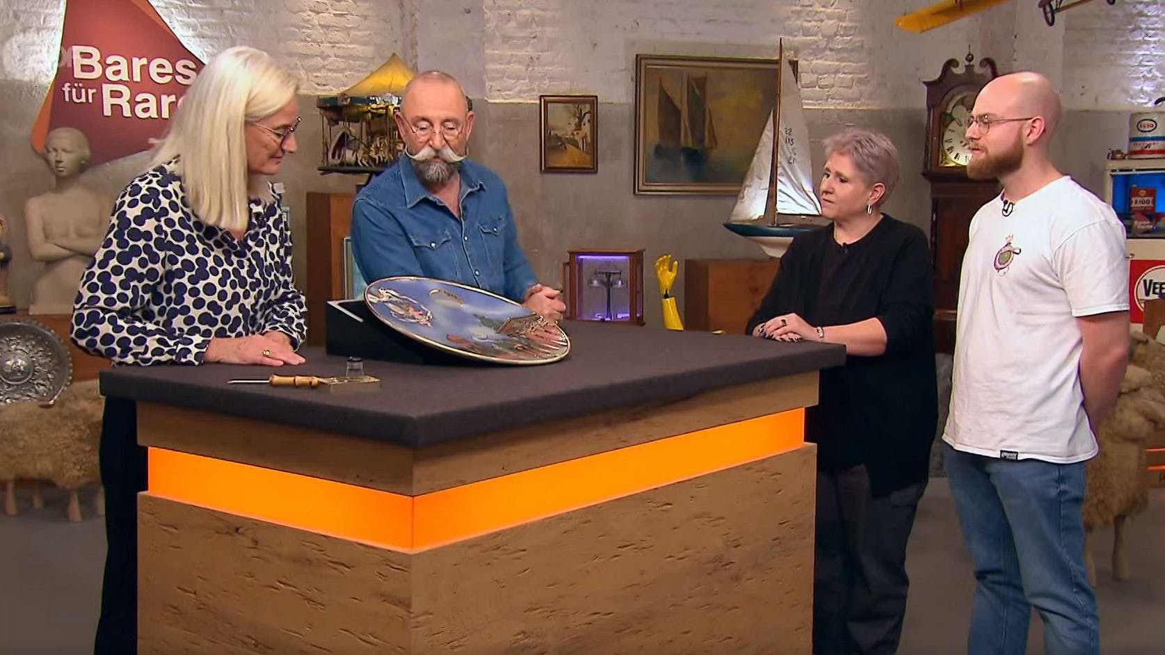 „Bares für Rares“-Expertin Dr. Friederike Werner (li.) inspiziert den Wandteller von Verkäuferin Bianca und ihrem Sohn Marvin (re.)