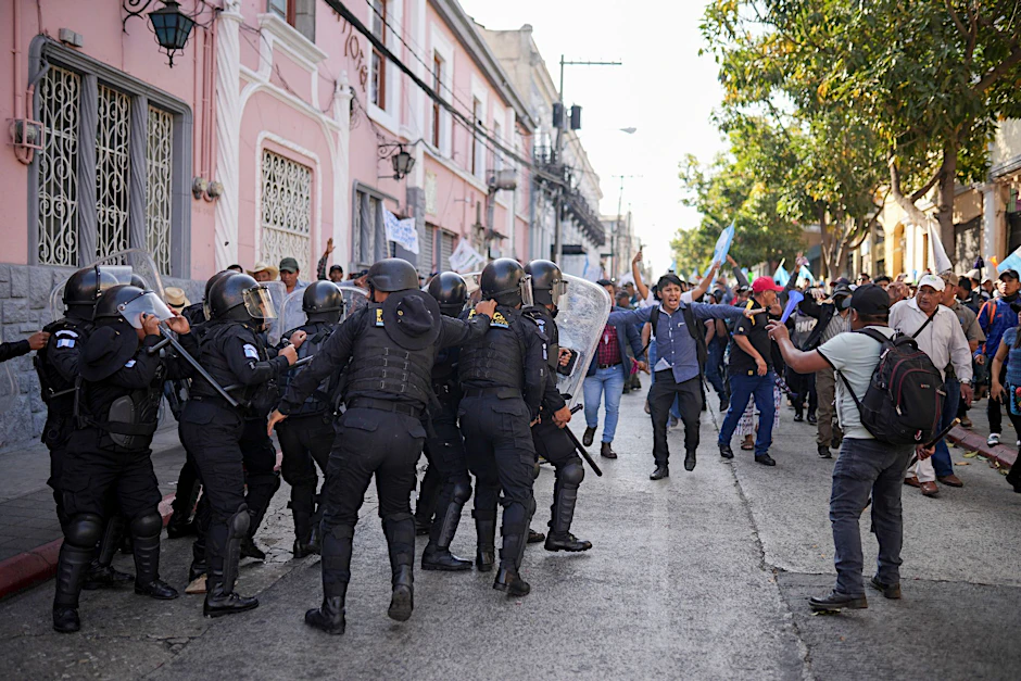 Die Polizei versucht, Anhänger des gewählten guatemaltekischen Präsidenten Arévalo zurückzuhalten, die vor dem Kongress in Guatemala-Stadt gegen eine Verzögerung des Beginns der Legislaturperiode protestieren.  