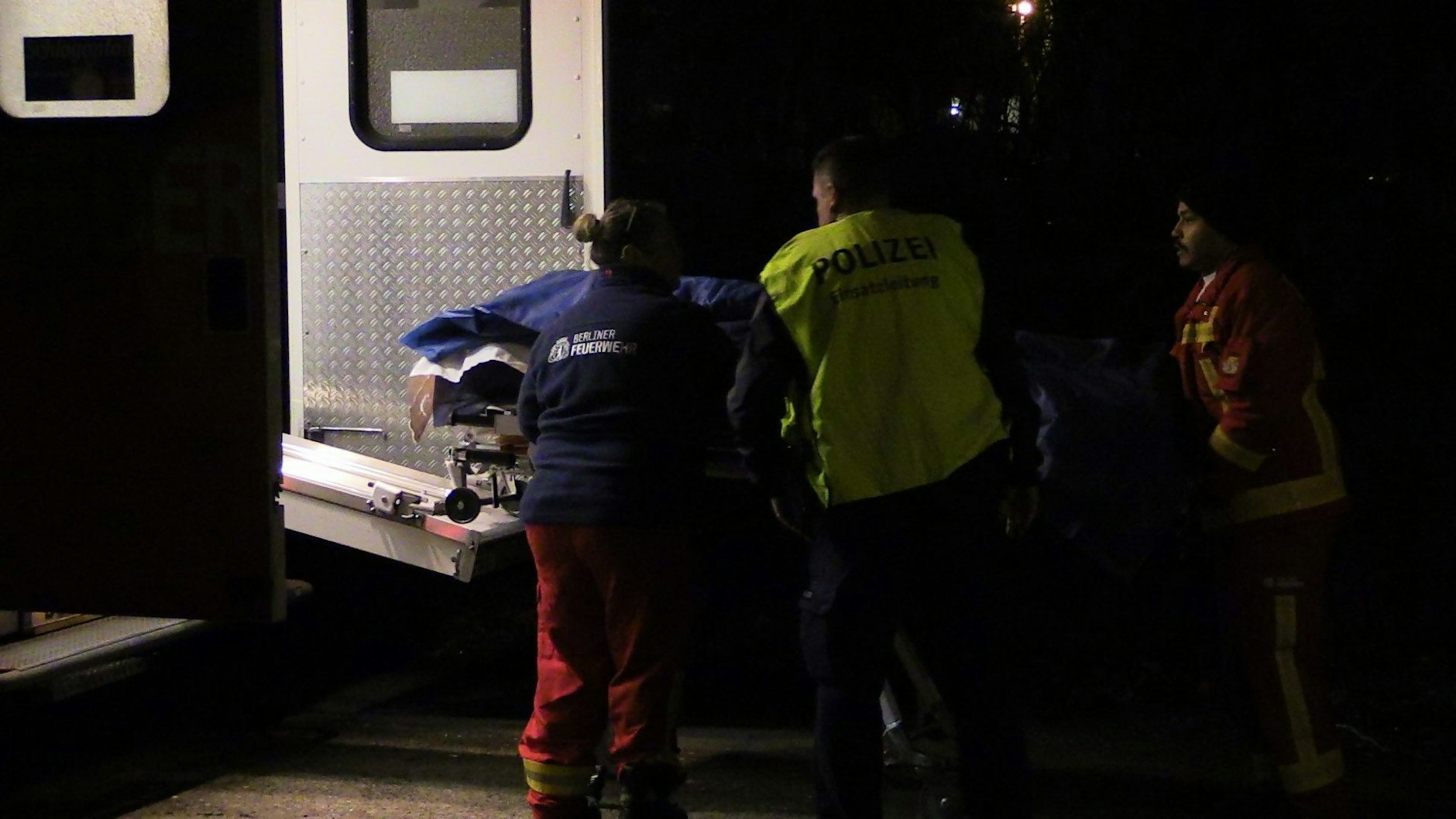 Einsatzkräfte bringen die Trage mit dem Leichnam des verunglückten E-Roller-Fahrers zum Krankenwagen.
