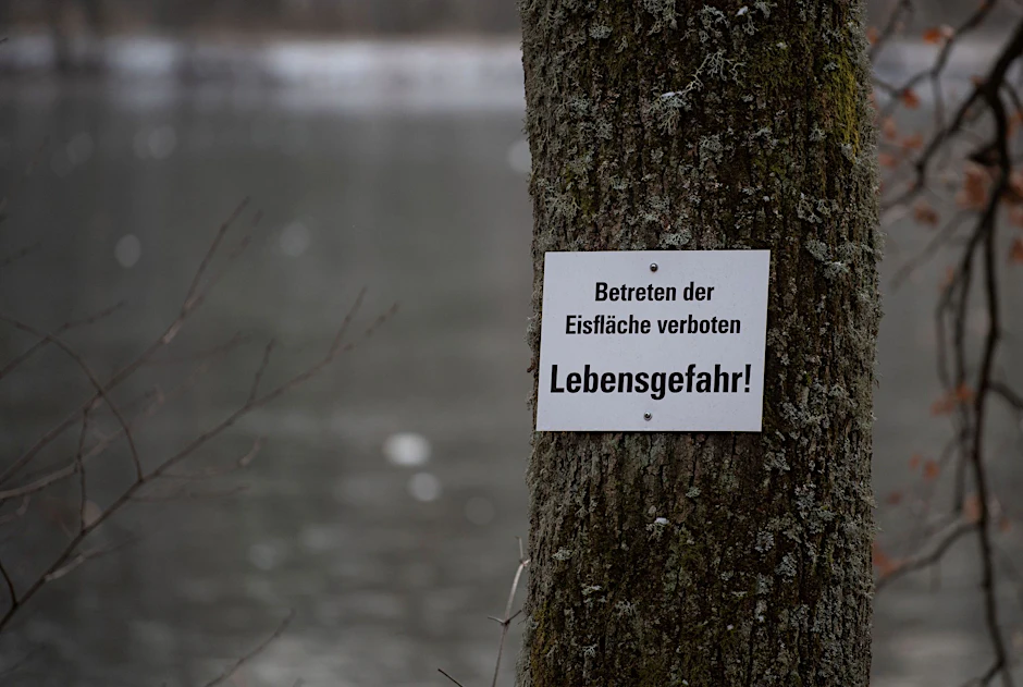 ARCHIV - Ein Schild mit der Aufschrift "Betreten der Eisfläche verboten - Lebensgefahr!" hängt an einem Baum.  