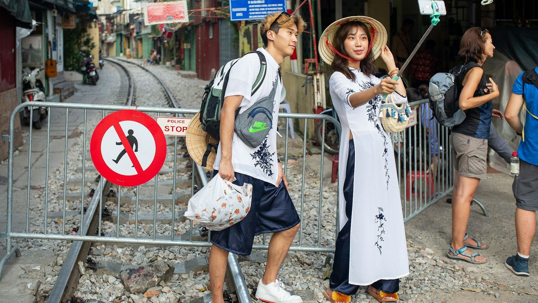 Selbstbild vor der abgesperrten „Train Street“ in Hanoi in Vietnam. Touristen ignorieren immer wieder die Barrieren mit großen Warnschildern, um an der fotogenen Zugstraße, die zwischen engen Häuserblocks hindurchführt, Selfies zu schießen.&nbsp;