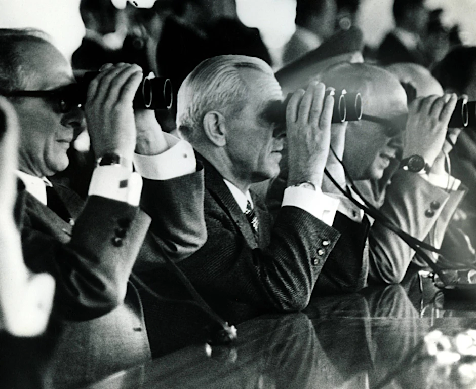 V.l.n.r.: Erich Honecker (Erster Sekretär  Zentralkomitee DDR), Staatsratsvorsitzender Willy Stoph (DDR) und Horst Sindermann (Vorsitzender Ministerrat der DDR) mit Fernglas in Magdeburg.