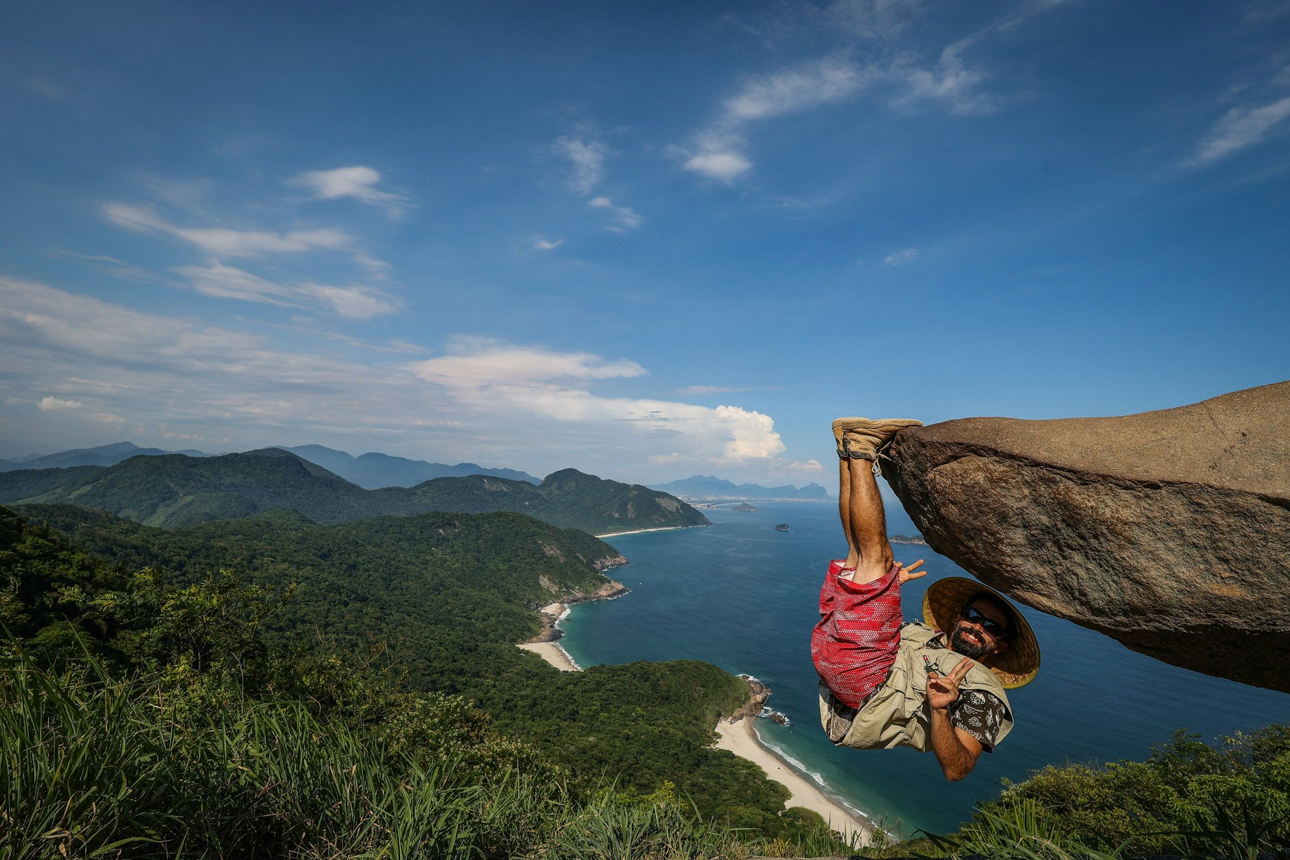Da schwindelt einem nur vom Hinsehen … Bernardo hängt am Felsen „Pedra do Telégrafo“ in Rio de Janeiro in Brasilien. Touristen lassen sich hier zu scheinbar waghalsigen Positionen hinreißen. Bei diesem Selfie-Hotspot ist das aber nicht ganz so gefährlich, wie es scheint.