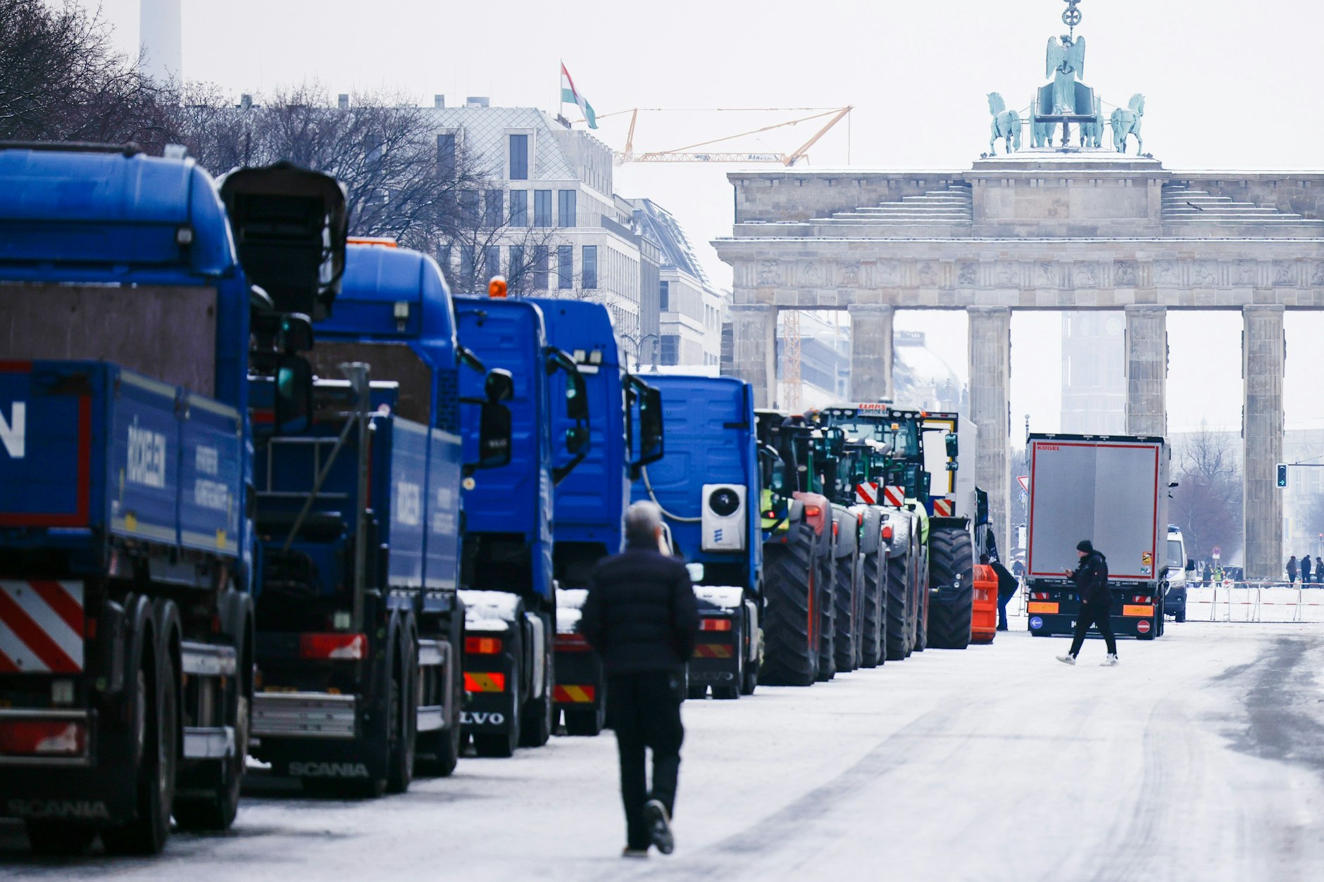 Lkws verschiedener Transportunternehmen stehen auf der Straße des 17. Juni vor dem Brandenburger Tor.