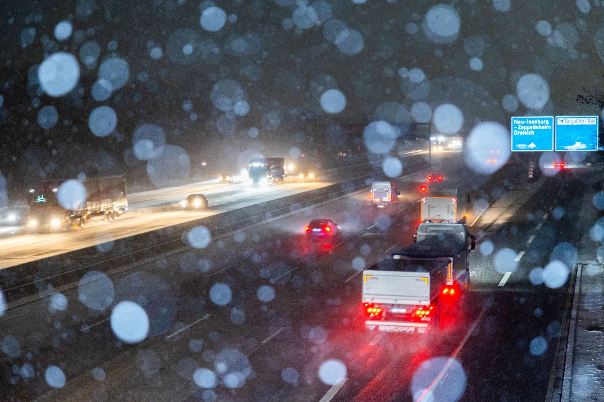 dpatopbilder - Autos und Lastwagen fahren bei Schneefall auf der Autobahn A5 nahe Zeppelinheim.  