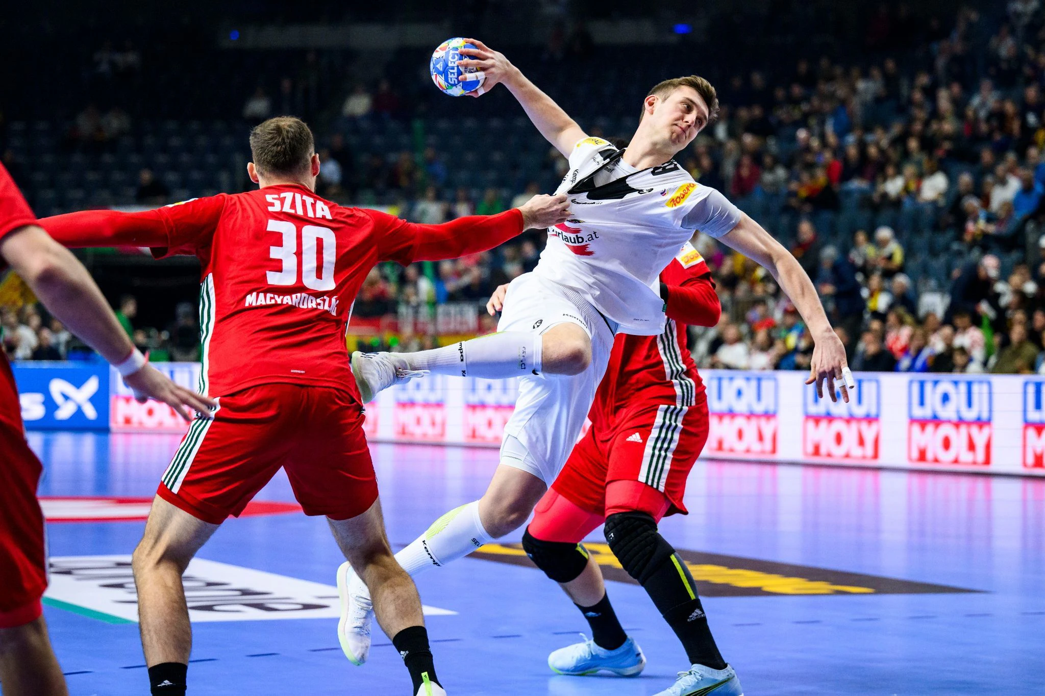 Gerangel bei der Handball-EM in der Lanxess Arena in Köln: Trotz Verteidigung der Ungarn Zoltan Szita und Bence Banhid kann der Österreicher Nikola Bilyk zum Wurf ansetzen.  