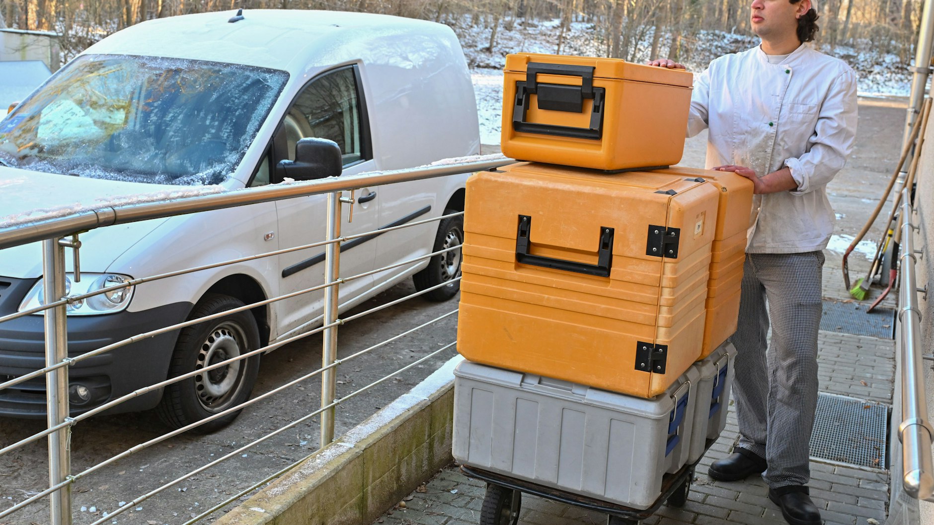 Der Praktikant Fabian Sliwa von der Wukantina bringt frisches Essen in Warmhalteboxen von der Küche zum Lieferfahrzeug.
