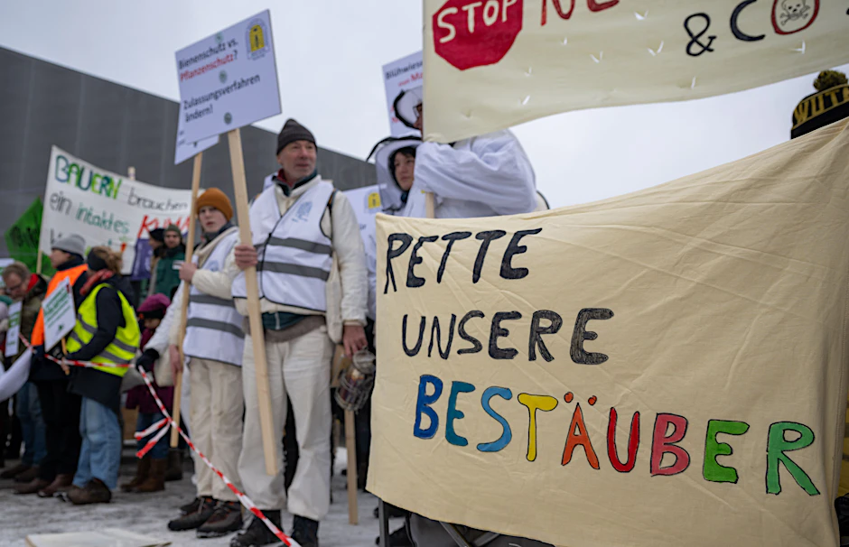 Demonstranten von der Initiative "Wir haben es satt!" stehen mit einem Transparent mit der Aufschrift "Rette unsere Bestäuber" am Rande der Agrarministerkonferenz vor dem CityCube.