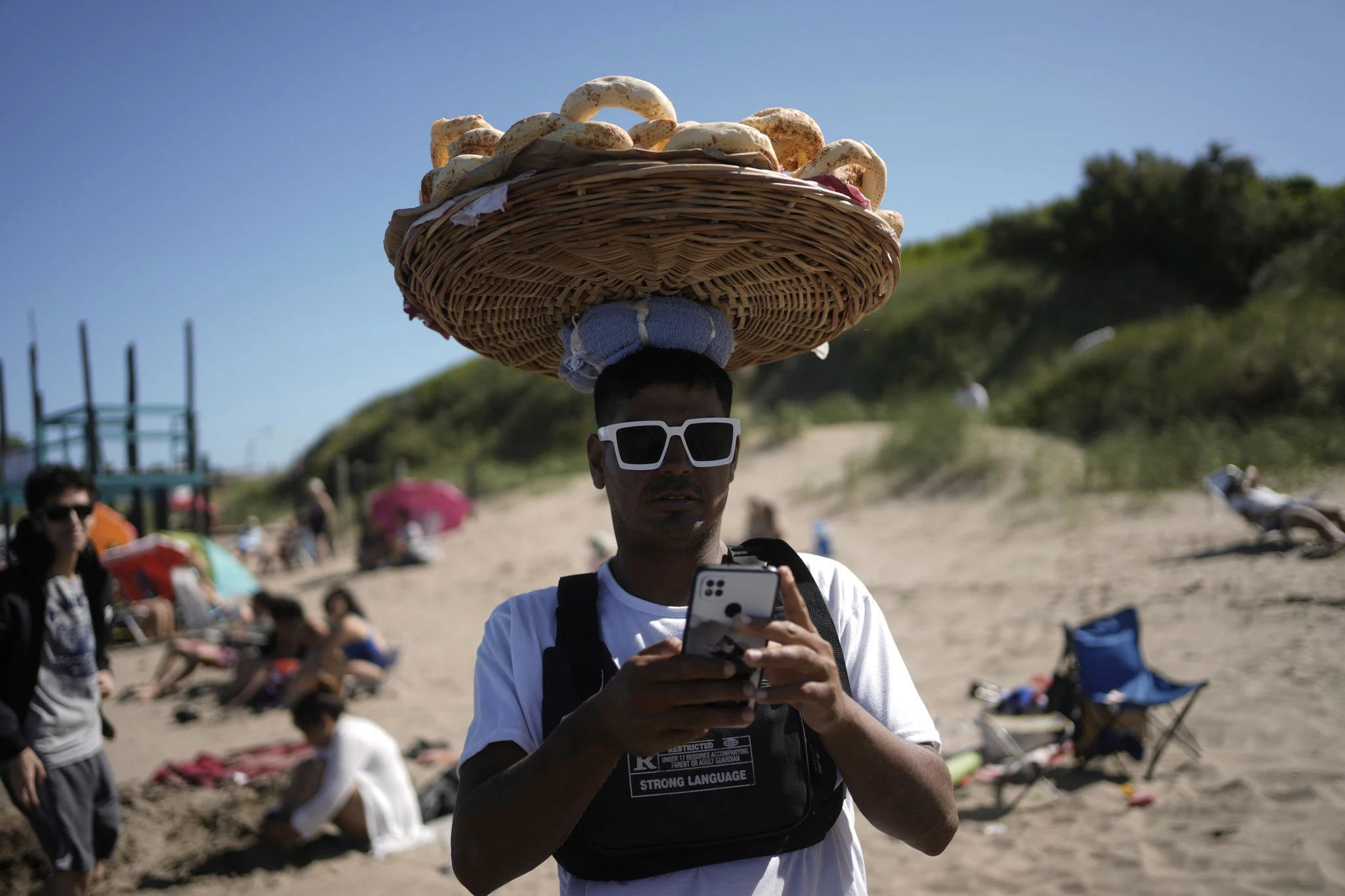 Sommerzeit in Argentinien: Ein Verkäufer bietet  am Strand von Las Toninas Gebäck feil.  
