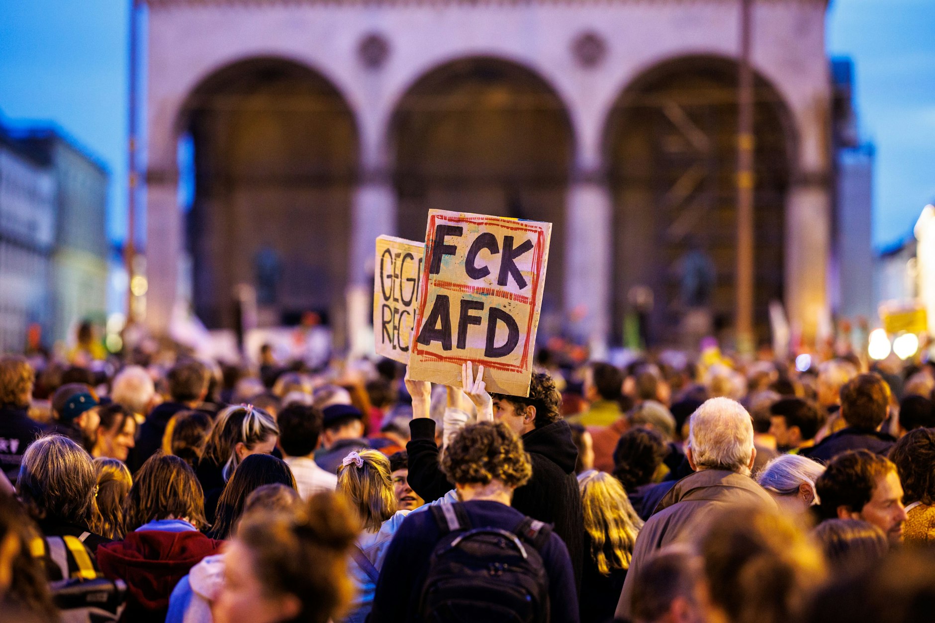 Die Teilnehmerin einer Demo steht mit einem Schild mit der Aufschrift FCK AFD auf einer Kundgebung auf dem Odeonsplatz in München.