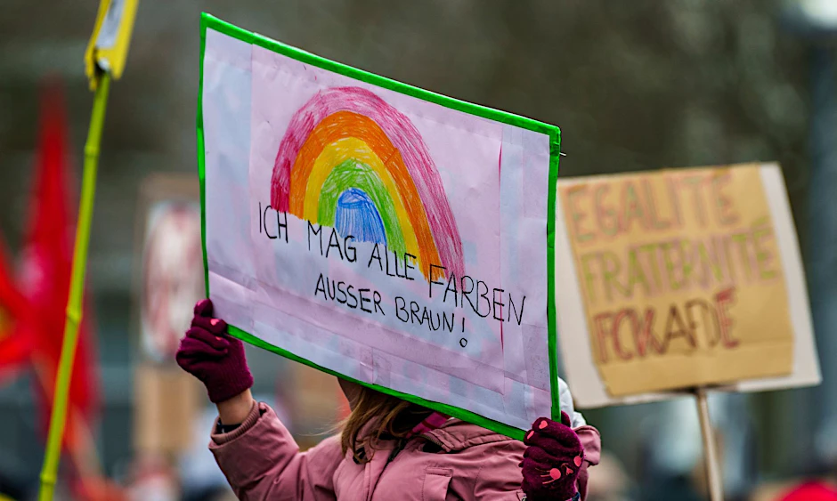 Ein Plakat "Ich mag alle Farben außer Braun!" wird auf einer Kundgebung gegen Rechtsextremismus hochgehalten.  