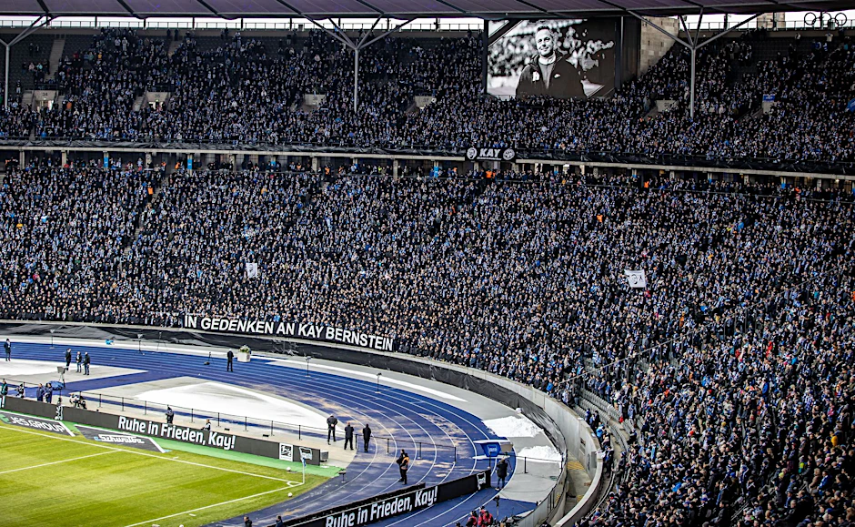 Fans von Hertha BSC stehen in der Ostkurve mit Schals und Bannern "In Gedenken an Kay Bernstein" und "Ruhe in Frieden, Kay!" in Trauer um den gestorbenen Hertha-Präsidenten Kay Bernstein.  