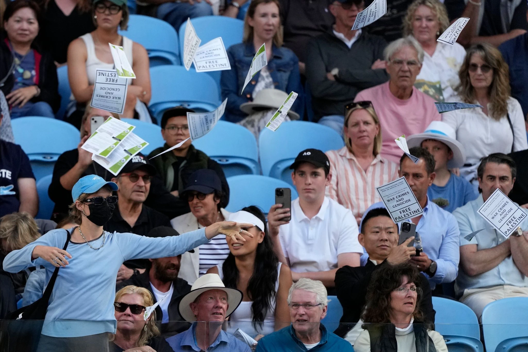 Eine Frau wirft während des Viertrundenmatches zwischen Alexander Zverev und Cameron Norrie bei den Australian Open in Melbourne Flugblätter mit der Aufschrift «Free Palestine» in die Luft.  
