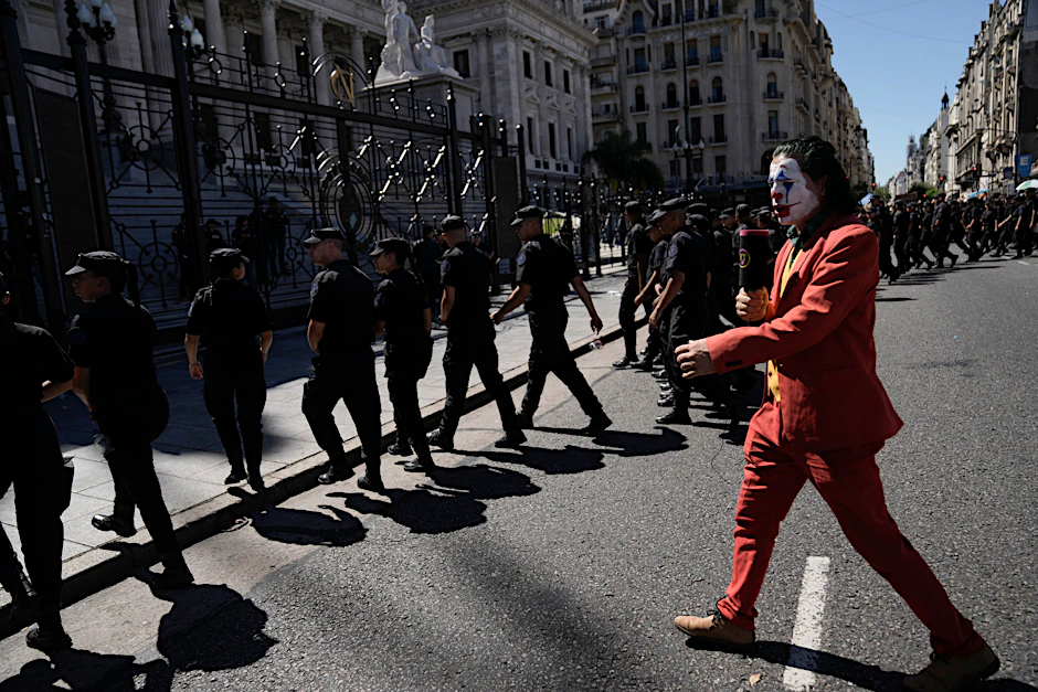 Ein Demonstrant im Joker-Kostüm imitiert einen Fernsehreporter während eines Protestes gegen den argentinischen Präsidenten Javier Milei.