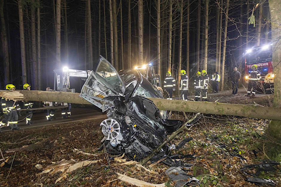 Feuerwehrleute bei dem Auto im österreichischen Aurolzmünster, das von einem Baumstamm durchbohrt wurde.&nbsp;