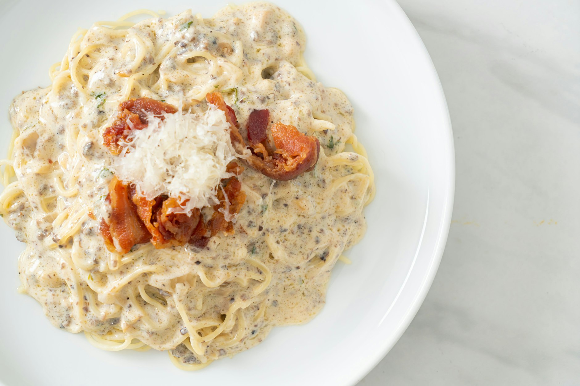 Ein famoses Gericht: Spaghetti mit Champignon-Sahnesauce, dazu kross gebratene Speckscheiben und etwas Parmesan.&nbsp;&nbsp;