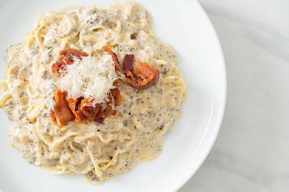 Ein famoses Gericht: Spaghetti mit Champignon-Sahnesauce, dazu kross gebratene Speckscheiben und etwas Parmesan.&nbsp;&nbsp;