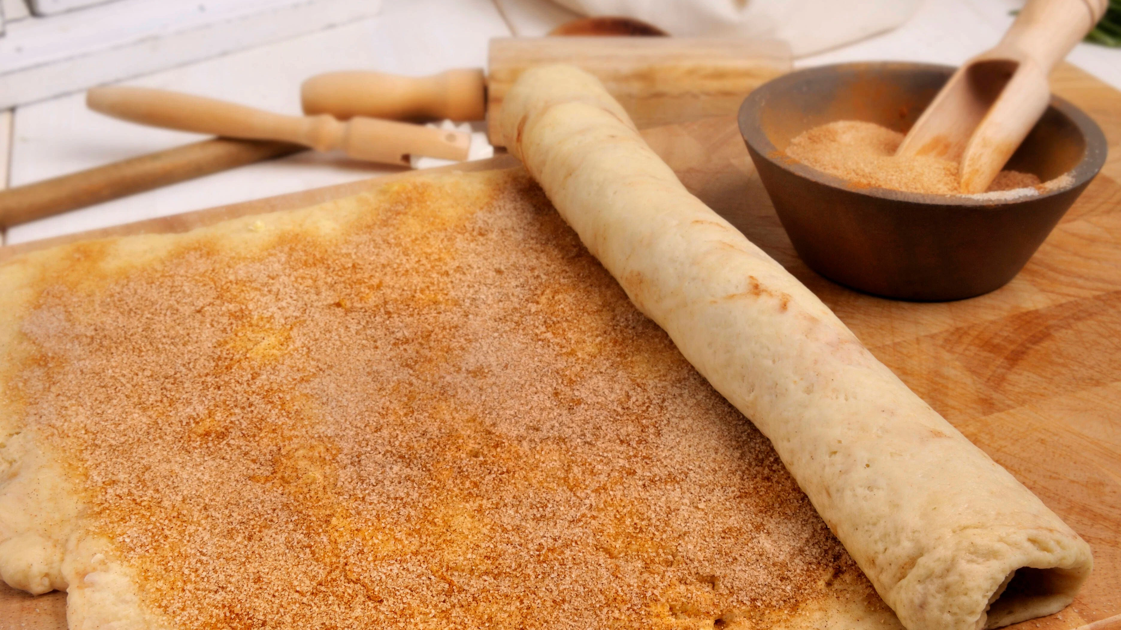 Für das Rezept die Rolle für die Zimtschnecken in 20 etwa zwei Zentimeter breite Stücke schneiden.