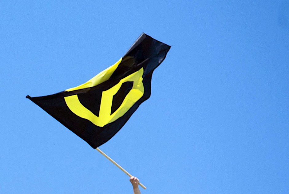 Berlin: Ein Aktivist mit einer Fahne der Identitären Bewegung auf dem Brandenburger Tor.