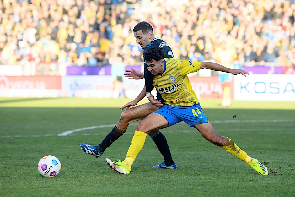 Braunschweigs Johan Gomez (r) im Zweikampf gegen Magdeburgs Andi Hoti.  