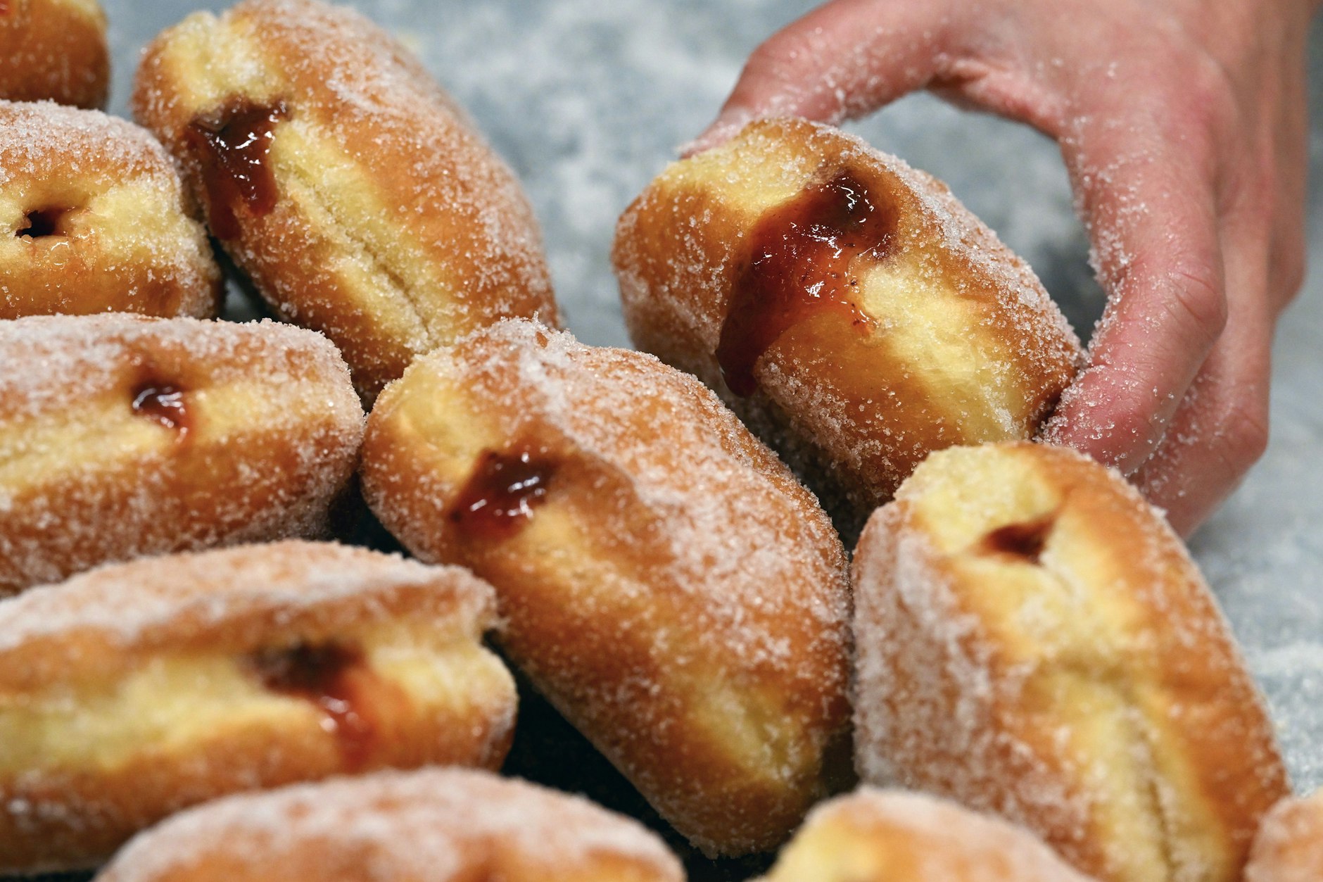 Frisch gebackene und mit selbstgemachtem Pflaumenmus gefüllte Pfannkuchen liegen auf einem Backblech in der Berliner Sugarclan GmbH.&nbsp;