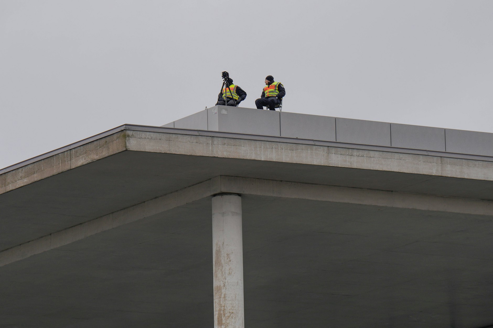 Polizisten befinden sich am Rande der Demo „Wir sind die Brandmauer“ auf einem Dach. 