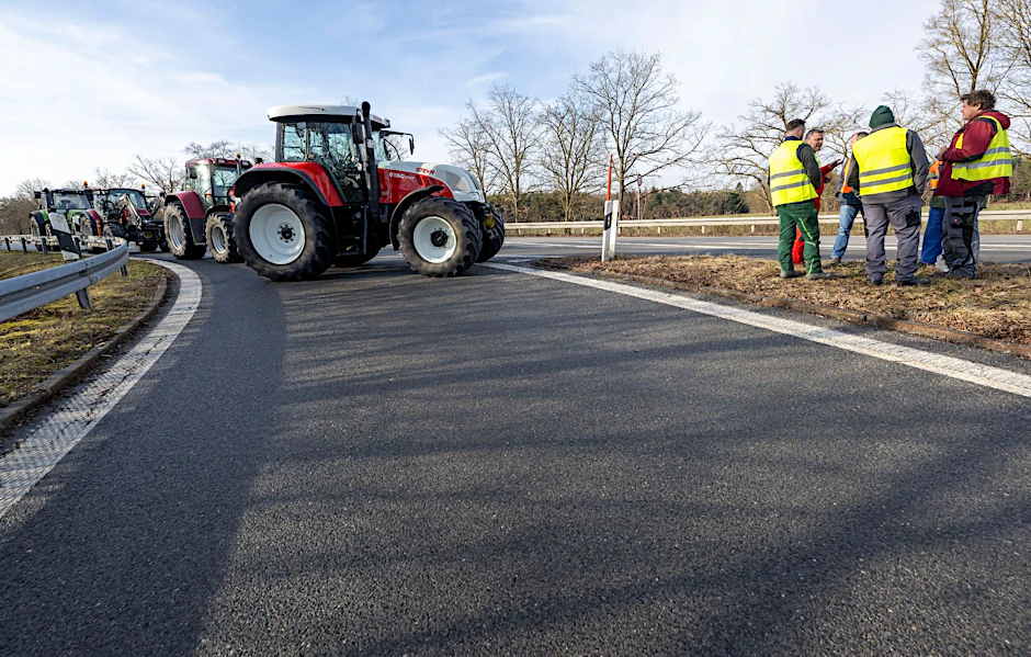 Landwirte blockieren mit Traktoren die Auffahrt einer Autobahn.  
