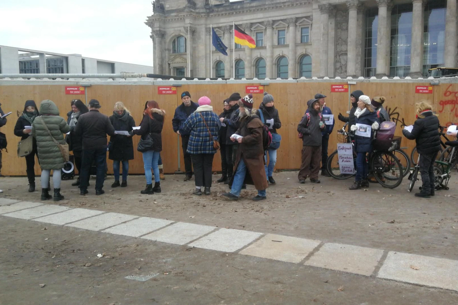 Eine kleine Gruppe Menschen hat sich vor dem Bundestag versammelt.