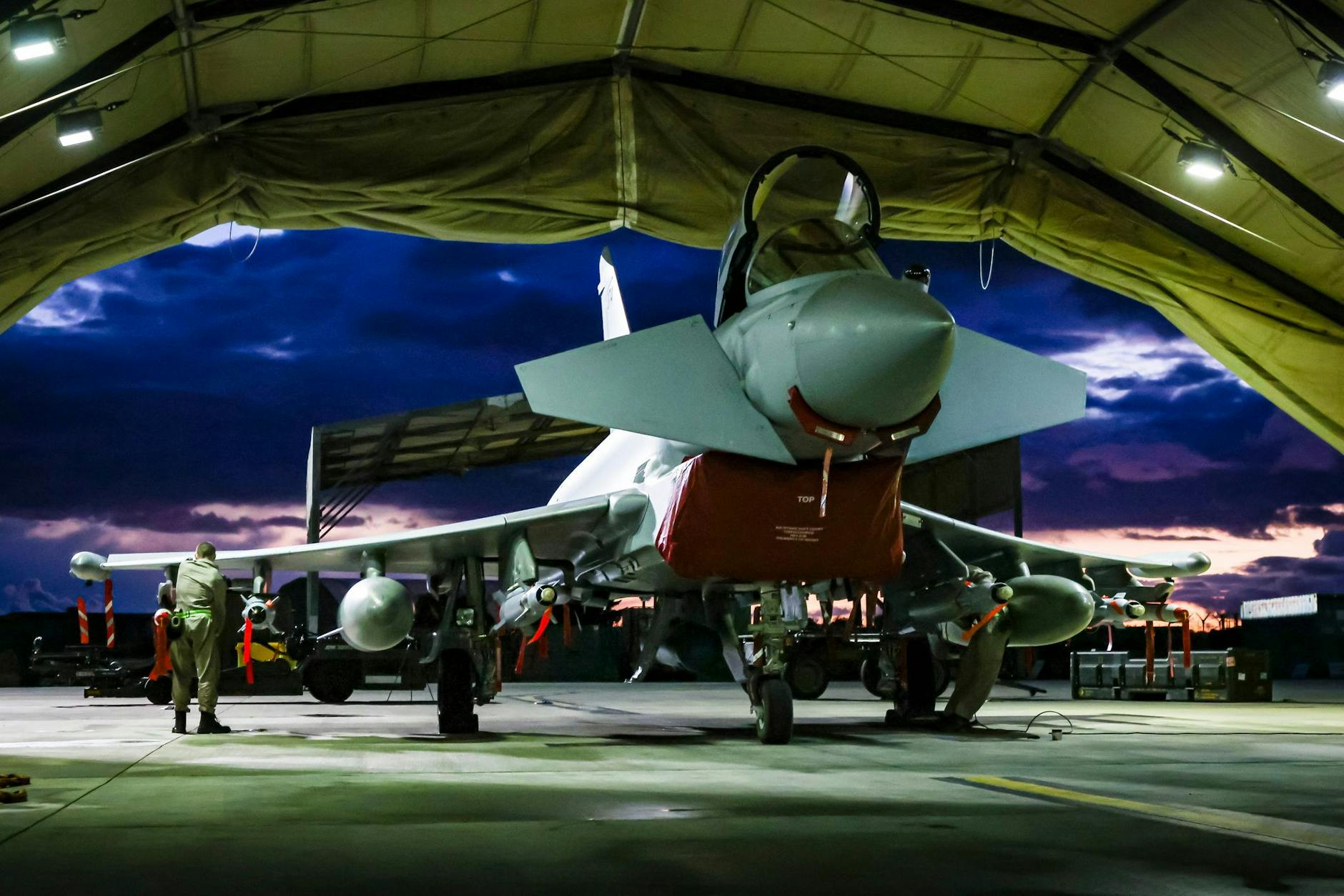 HANDOUT - Die von Verteidigungsministerium des Vereinigten Königreichs zur Verfügung gestellte Aufnahme zeigt Waffentechniker der Royal Air Force bei der Vorbereitung eines Kampfflugzeugs vom Typ Typhoon FGR4. ht 2024/UK Ministry of Defence/dpa