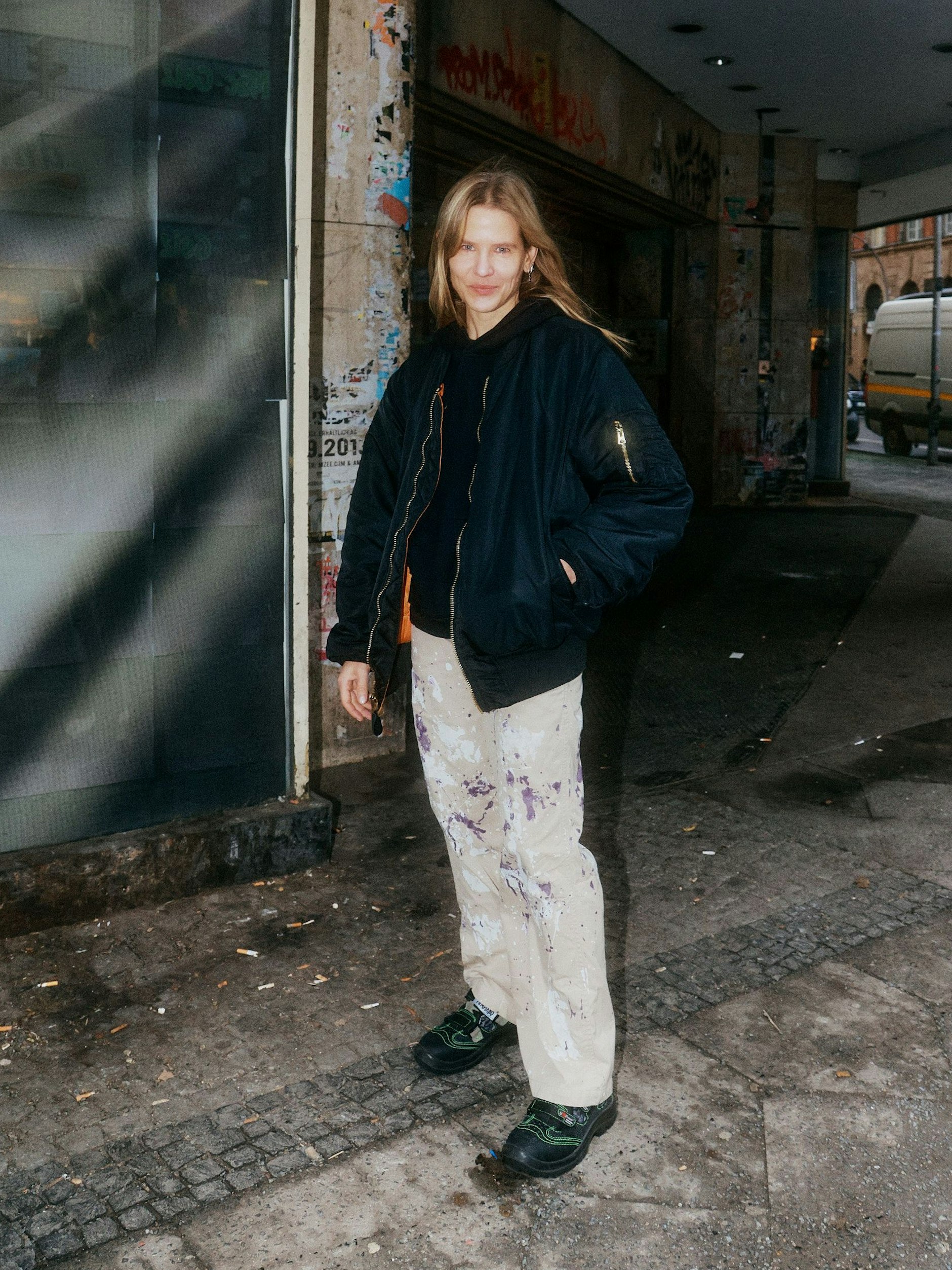 Die Berliner Kostümbildnerin Aino Laberenz trägt zur Bomberjacke eine Hose mit Farbklecksen von Needles.