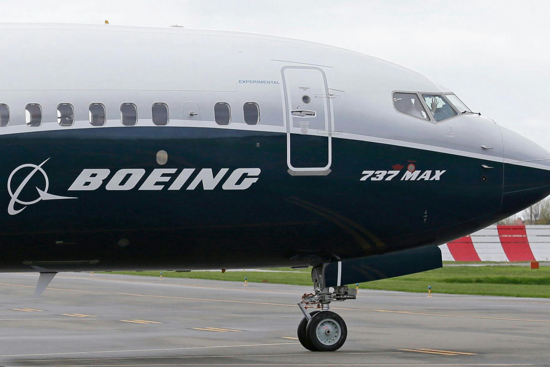 Ein Pilot winkt aus der Pilotenkabine eines Flugzeuges vom Typ Boeing 737 MAX 9 auf dem Flughafen. 