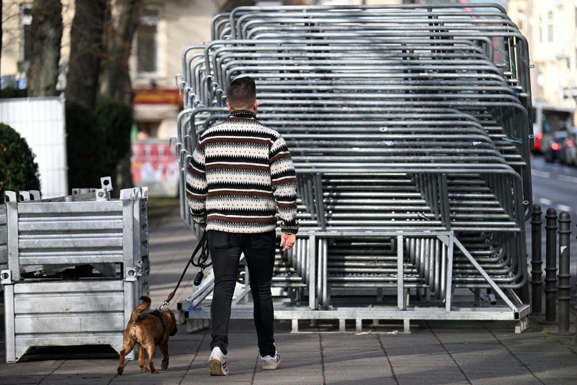 Ausweichmanöver beim Spaziergang: Absperrgitter, die für die Karnevalsumzüge in Köln aufgestellt werden sollen, stehen auf einem Gehsteig bereit. In drei Tagen beginnt in der Domstadt der Straßenkarneval.