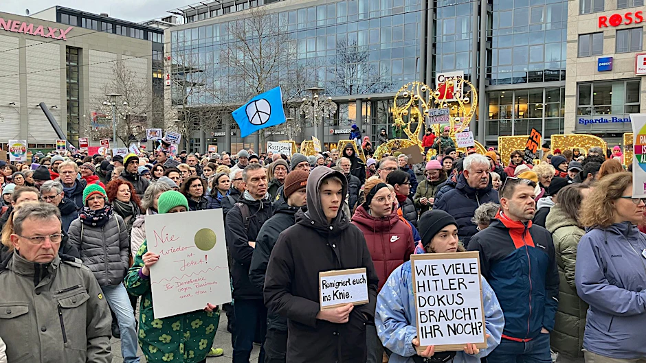 Demonstranten mit Plakaten vor dem Magdeburger Hauptbahnhof.  