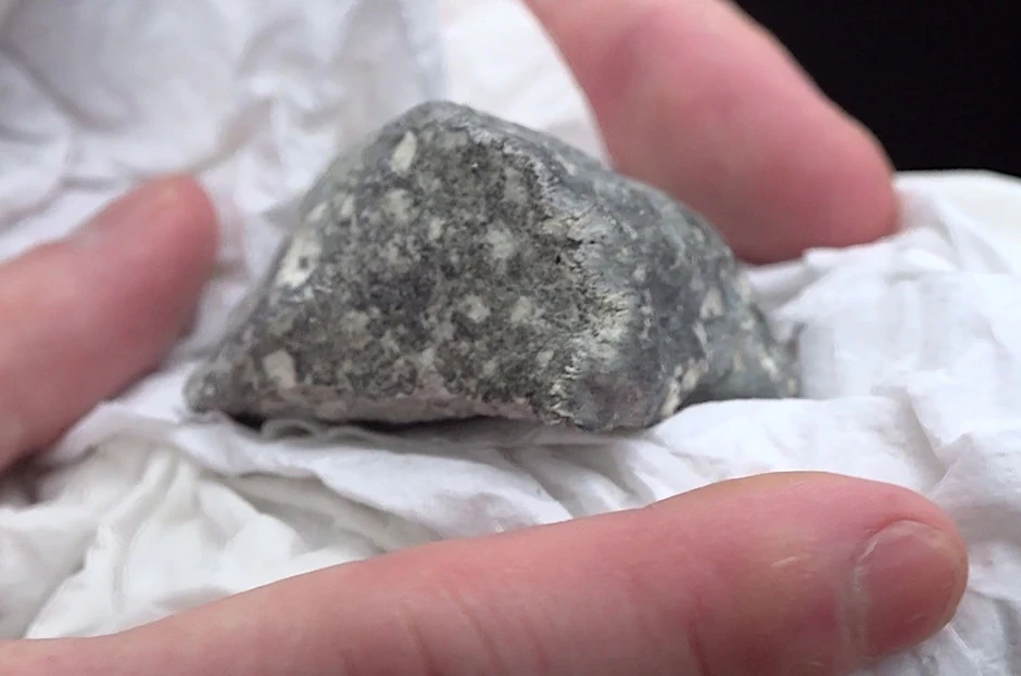 Ein mutmaßliches Meteoritenteil liegt in einem Papiertaschentuch.  