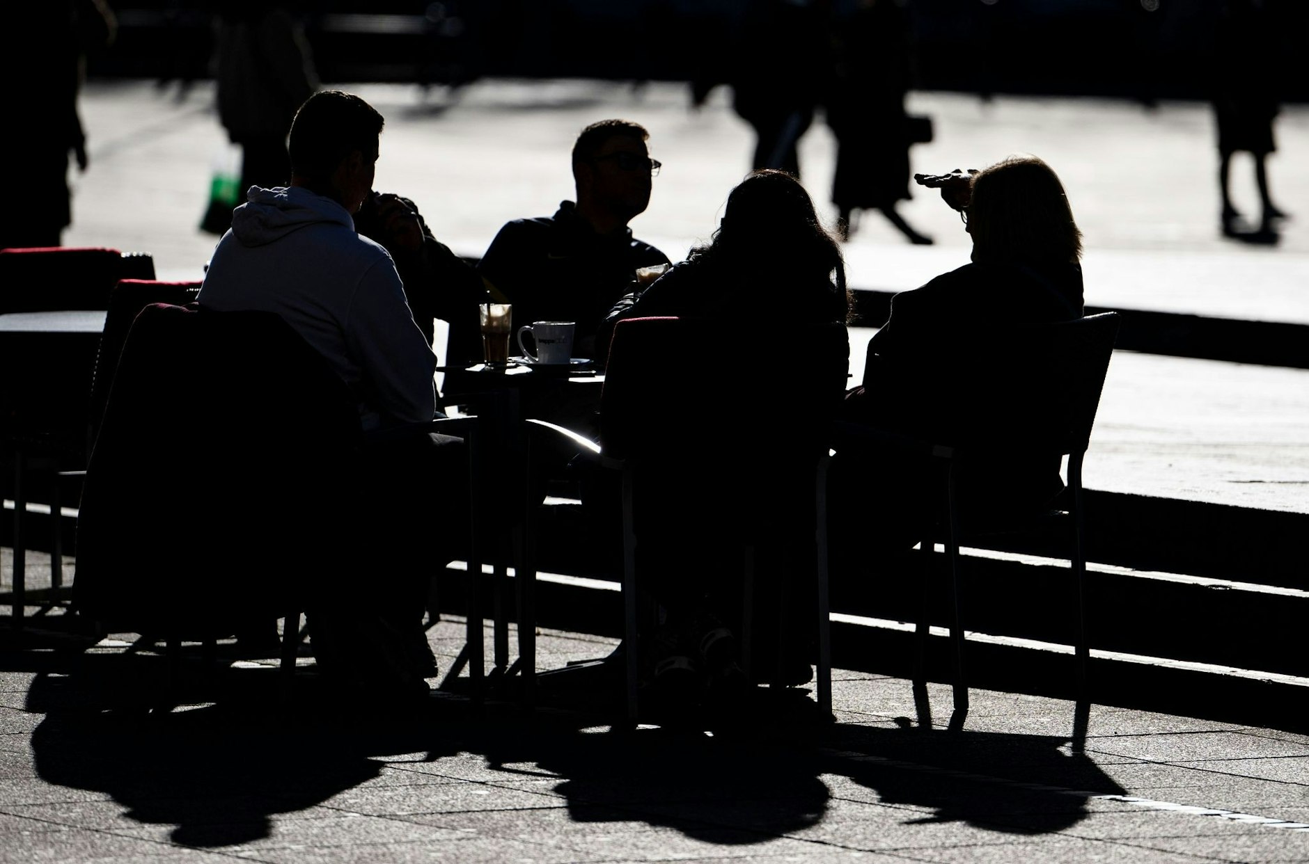 Menschen sitzen bei Sonnenschein in der Stuttgarter Innenstadt. Mitten im Winter ist derzeit kein Winterwetter in Sicht.  