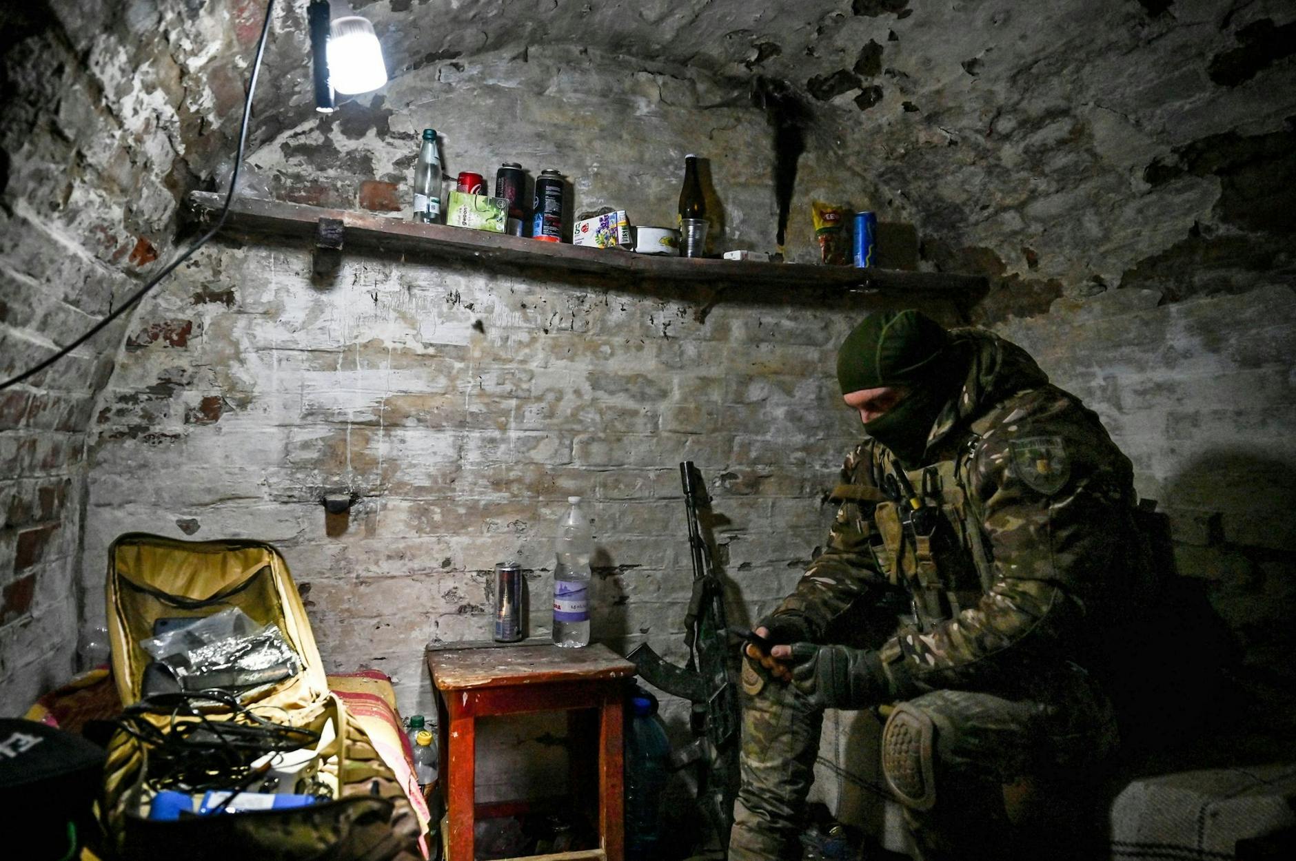 dpatopbilder - Kontakt nach draußen: Ein Mitglied einer ukrainischen Polizeieinheit sitzt in einem Keller bei Orichiw und blickt auf sein Smartphone. nform.com/ Ukrinform/dpa