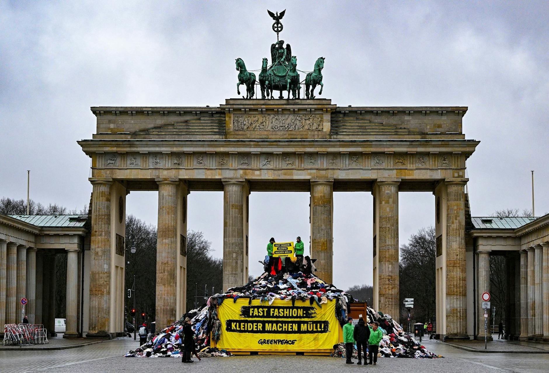 Heute beginnt die Fashion Week in Berlin. Aktivistinnen und Aktivisten von Greenpeace protestieren zu diesem Anlass gegen die Verschmutzung der Umwelt in Ghana durch Fast Fashion-Kleidung. Dazu haben sie symbolisch einen Berg aus Kleidung vor dem Brandenburger Tor errichtet.