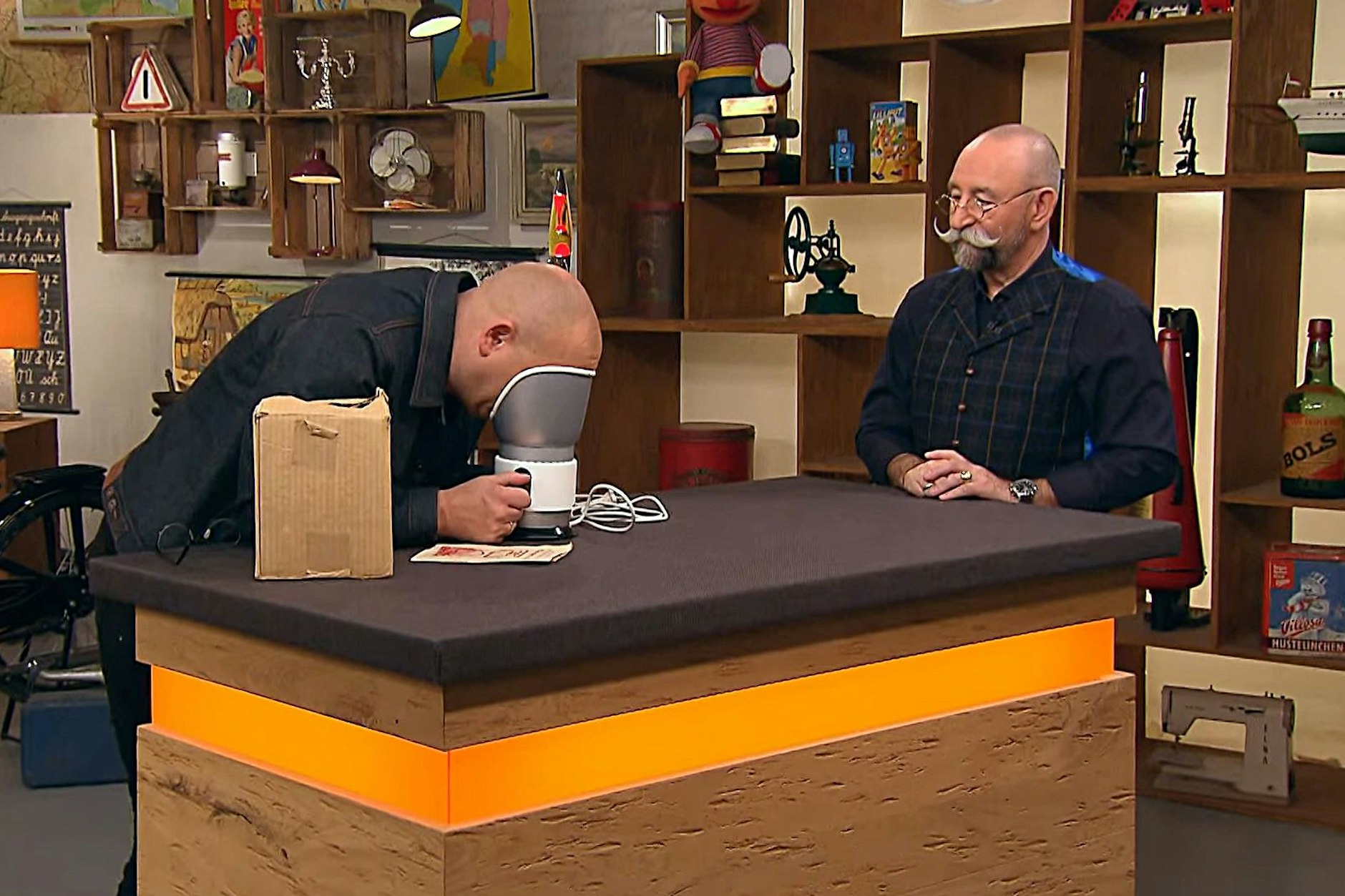 Schräges Objekt bei „Bares für Rares“: Experte Sven Deutschmanek zeigt Moderator Horst Lichter, wie die Gesichts-Sauna aus der DDR funktioniert.
