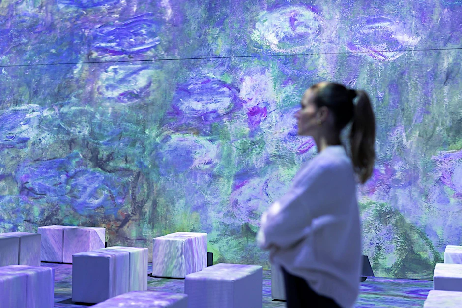 ARCHIV - Eine Mitarbeiterin steht in der multimedialen Ausstellung «Monets Garten».  