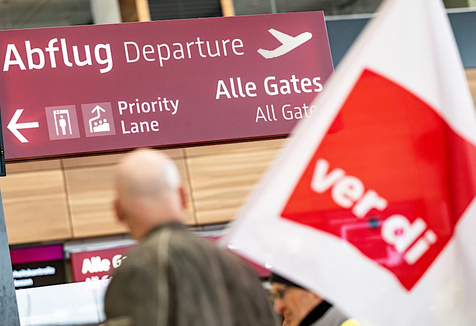 ARCHIV - Streikende laufen während eines Warnstreiks im März 2023 durch das Terminal 1 des BER-Flughafens.  