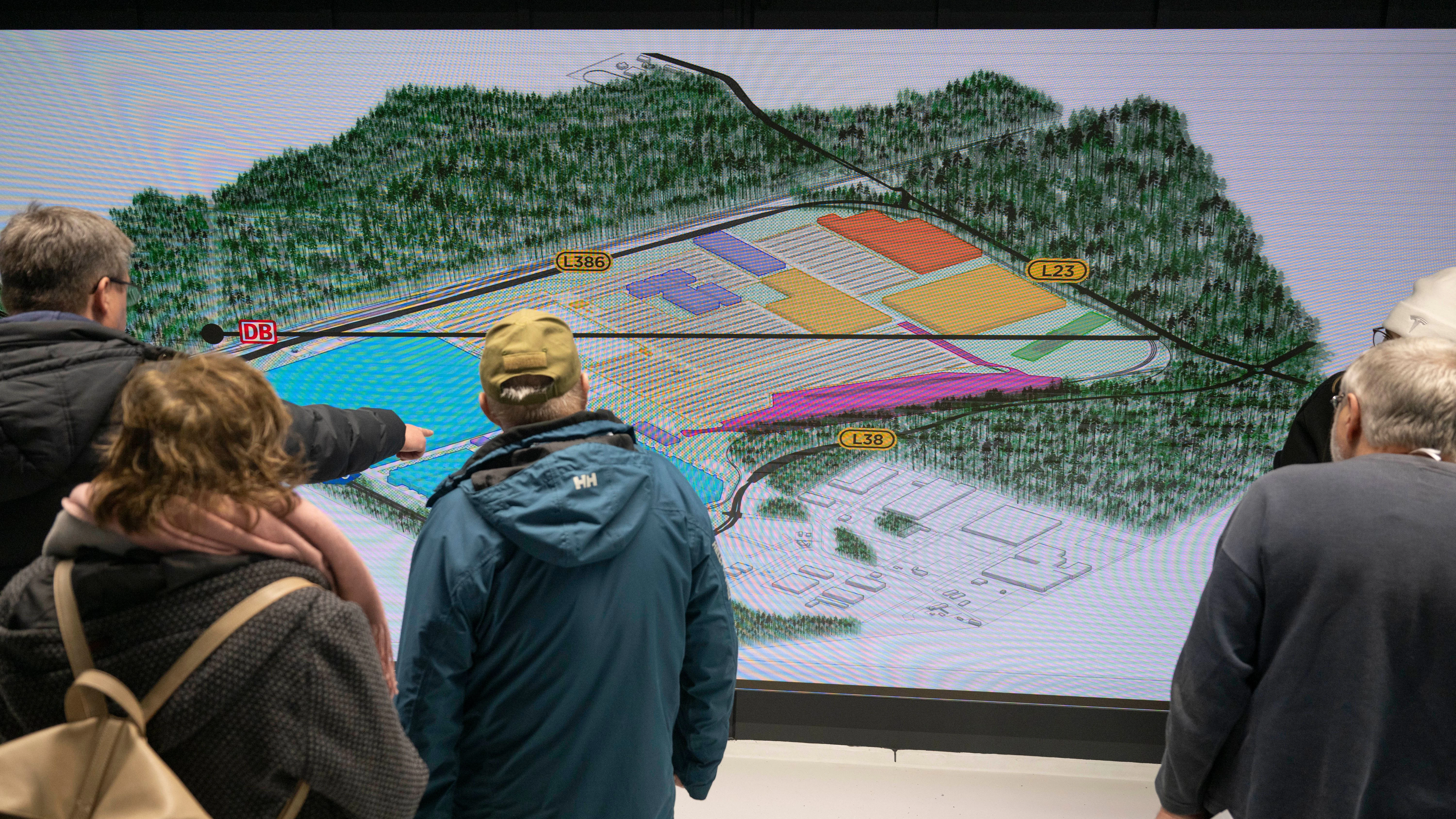 Besucher schauen sich bei einer Informationsveranstaltung den Bauplan für die Erweiterung der Tesla-Fabrik an.&nbsp;