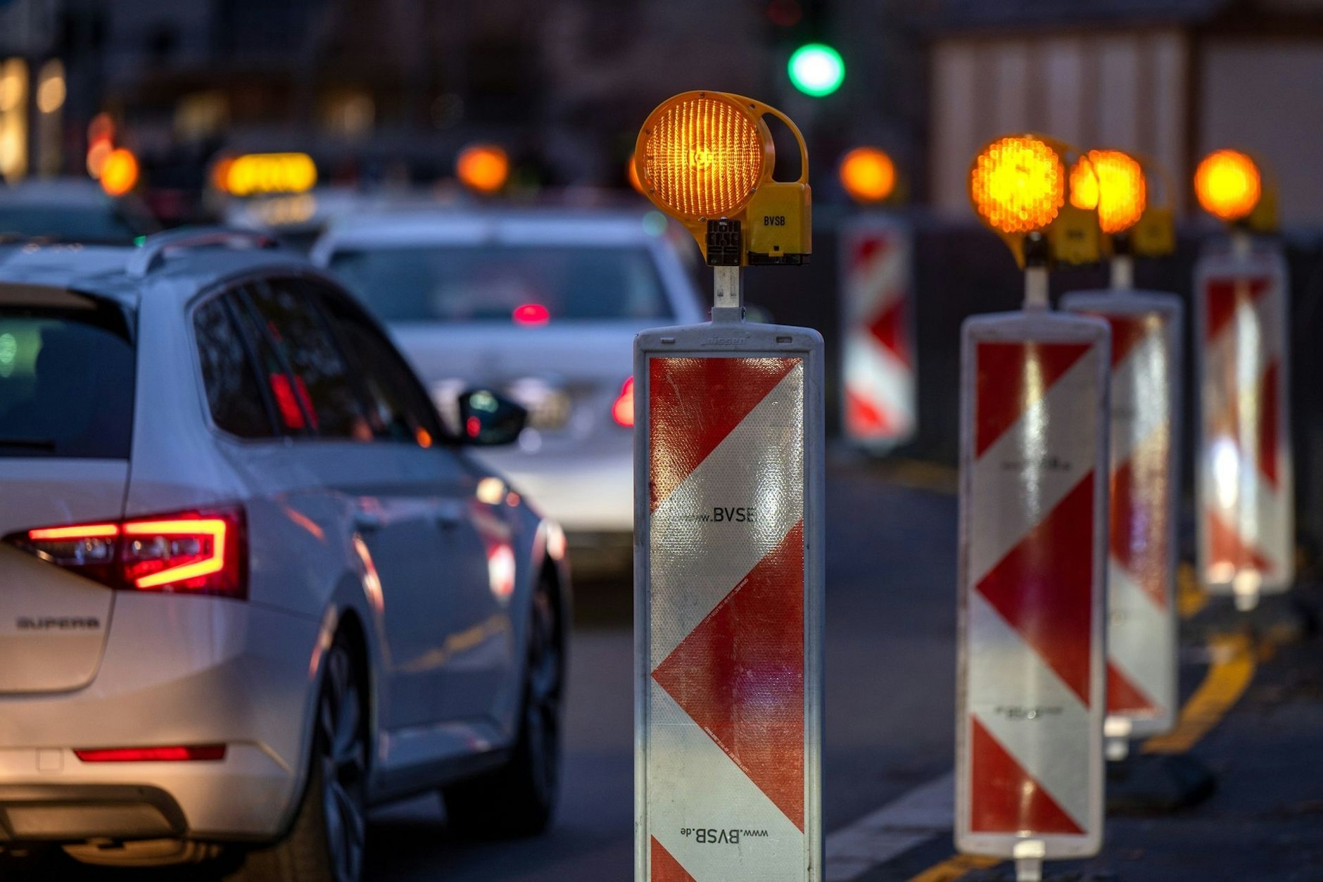 Autos stehen in Berlin am Abend im Stau an einer Baustelle.