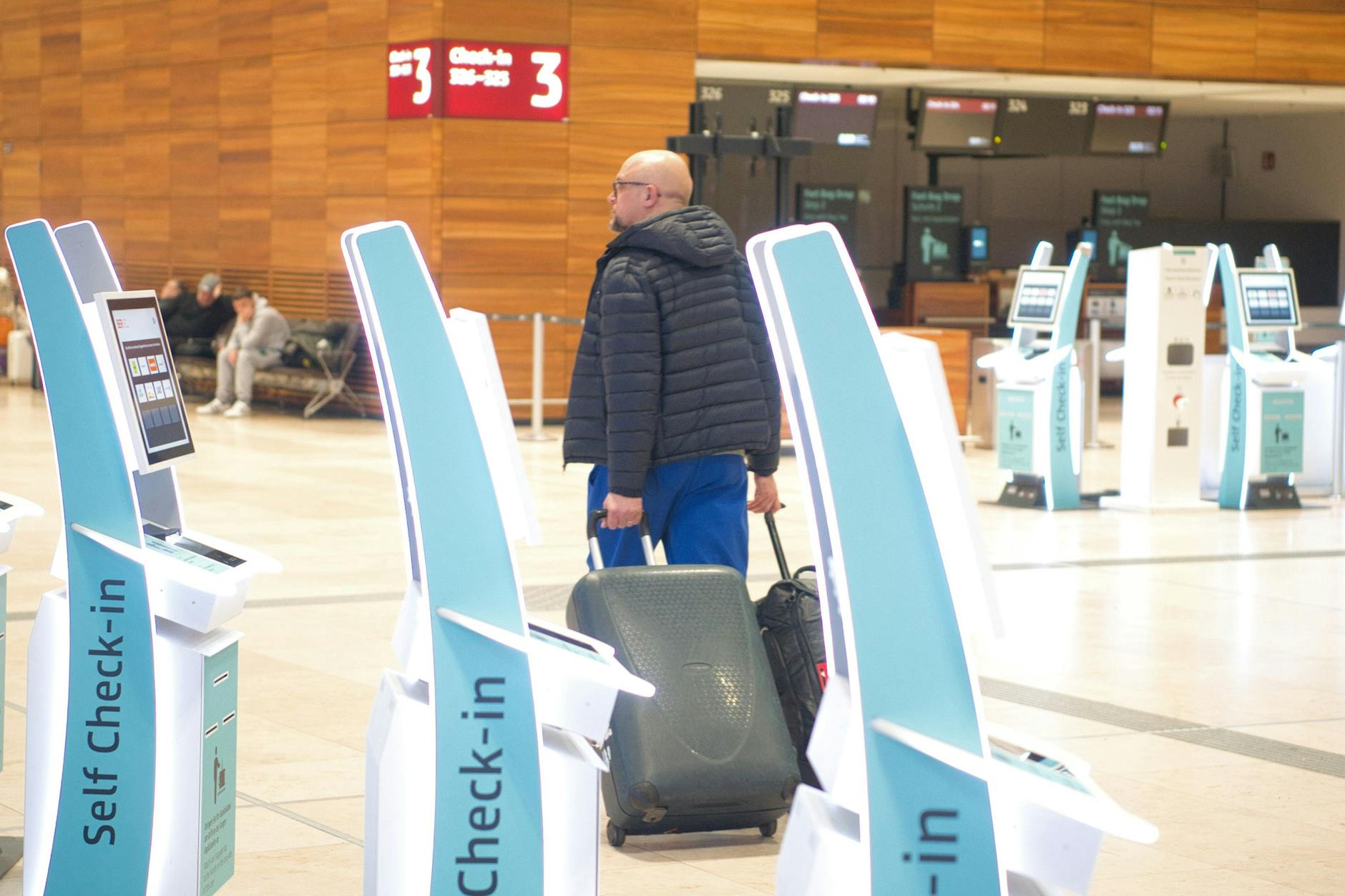Ein Reisender läuft durch die fast leere Halle am Flughafen BER. Die Gewerkschaft Verdi hat das Bodenpersonal der Lufthansa zu einem ganztägigen Warnstreik an mehreren Flughäfen aufgerufen.