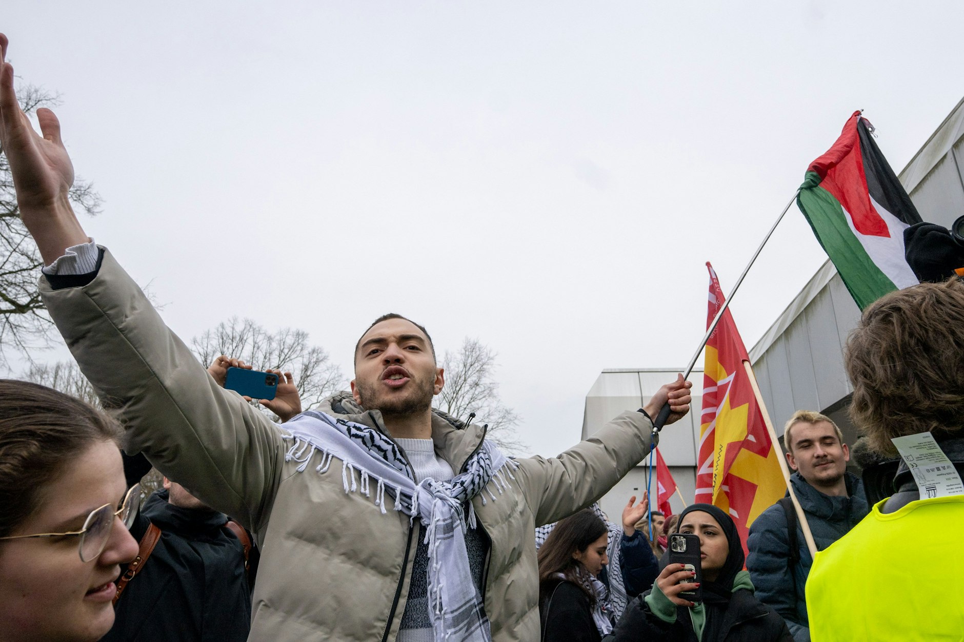 Ein Teilnehmer der propalästinensischen Kundgebung vor der Mensa II der Freien Universität gestikuliert in Richtung Gegendemonstranten.