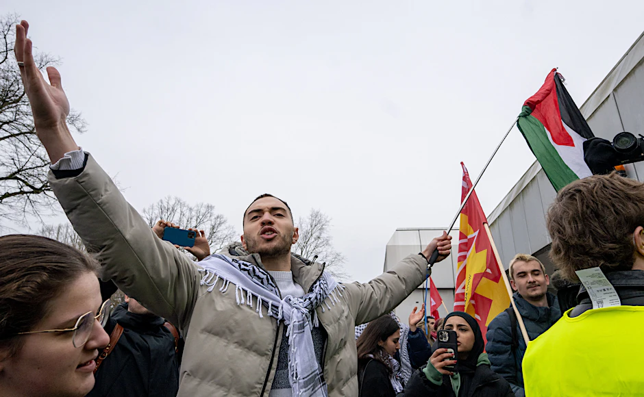 Ein Teilnehmer der propalästinensischen Kundgebung vor der Mensa II der Freien Universität gestikuliert in Richtung Gegendemonstranten. 