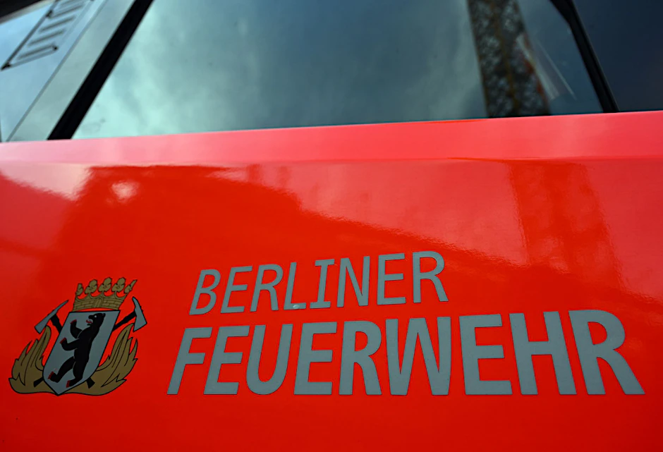 ARCHIV - Der Schriftzug «Berliner Feuerwehr» und das Wappen auf der Tür eines Feuerwehrfahrzeuges.  